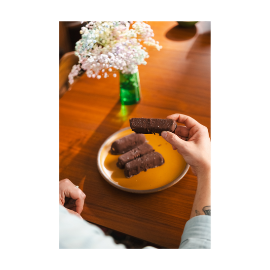 A hand holding a Darë Vegan Cheese vegan ice cream bar