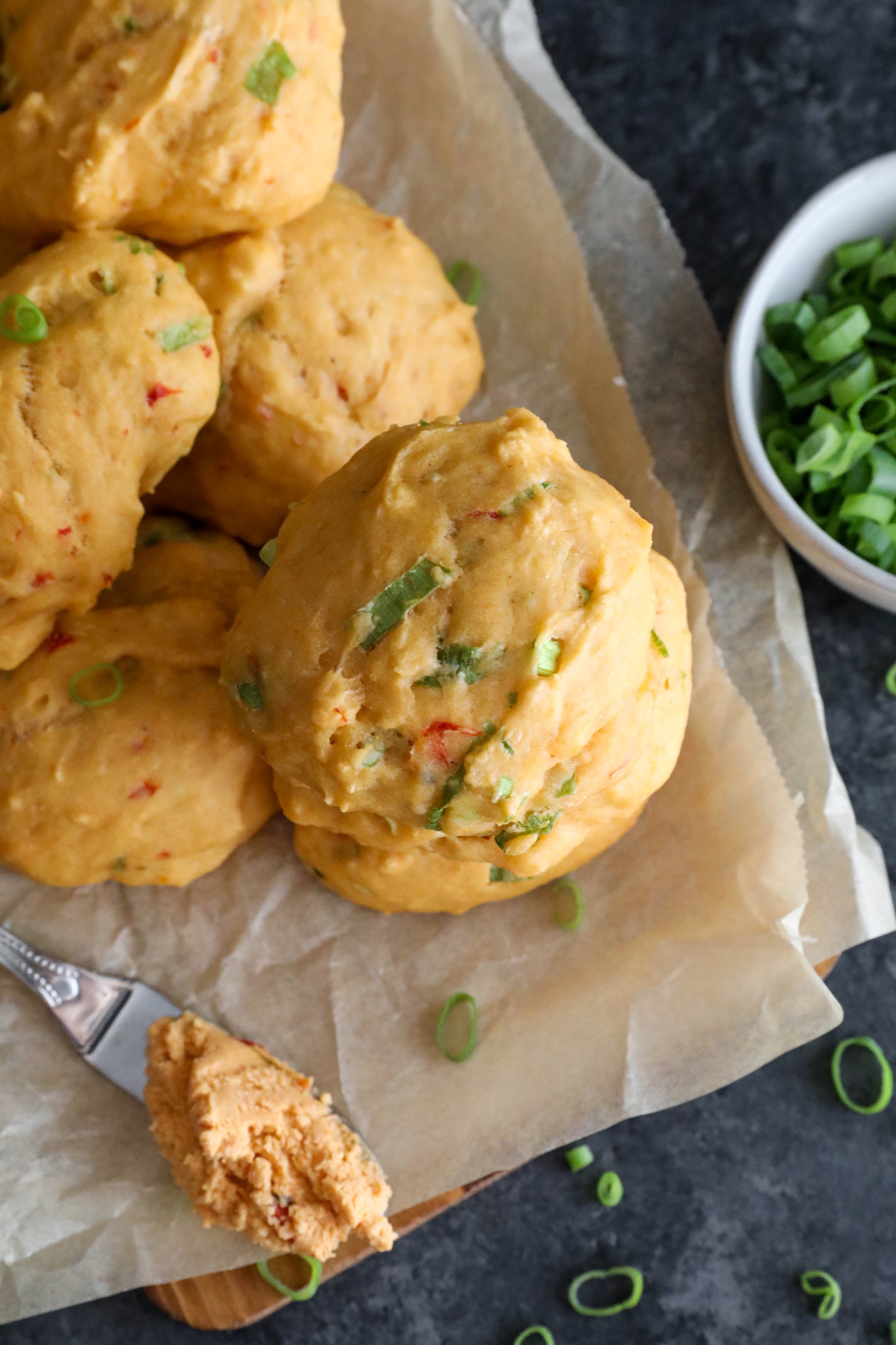 Biscuits on parchment paper with smoked pimento on a knife