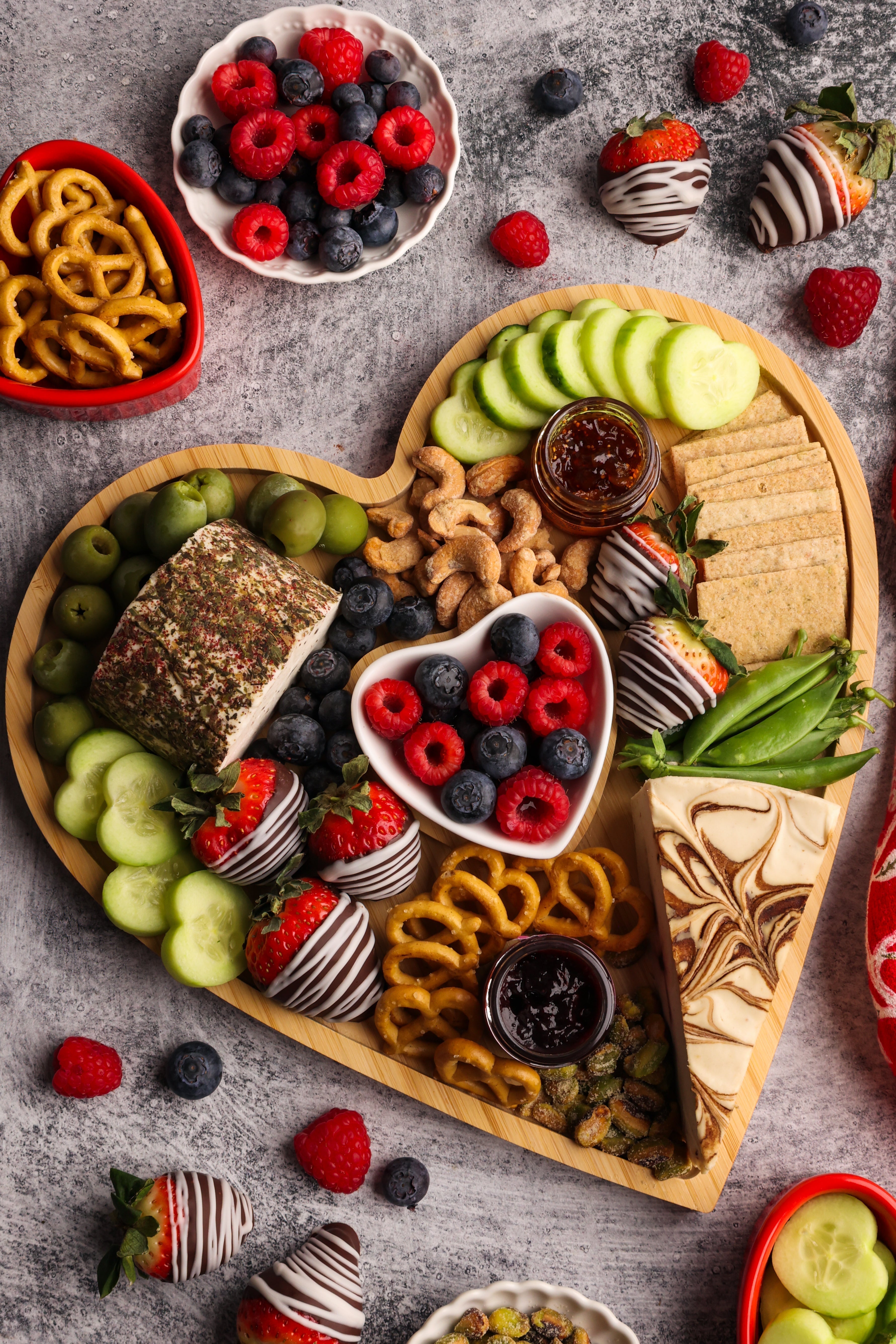 Cheeseboard in the shape of a heart surrounded by fruit