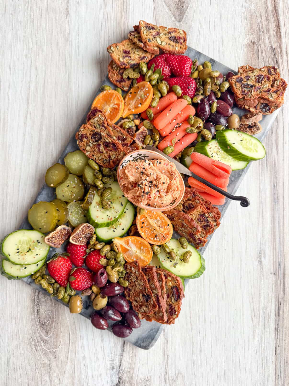Cheese board with fruits, veggies, crackers and smoked pimento dare vegan cheese