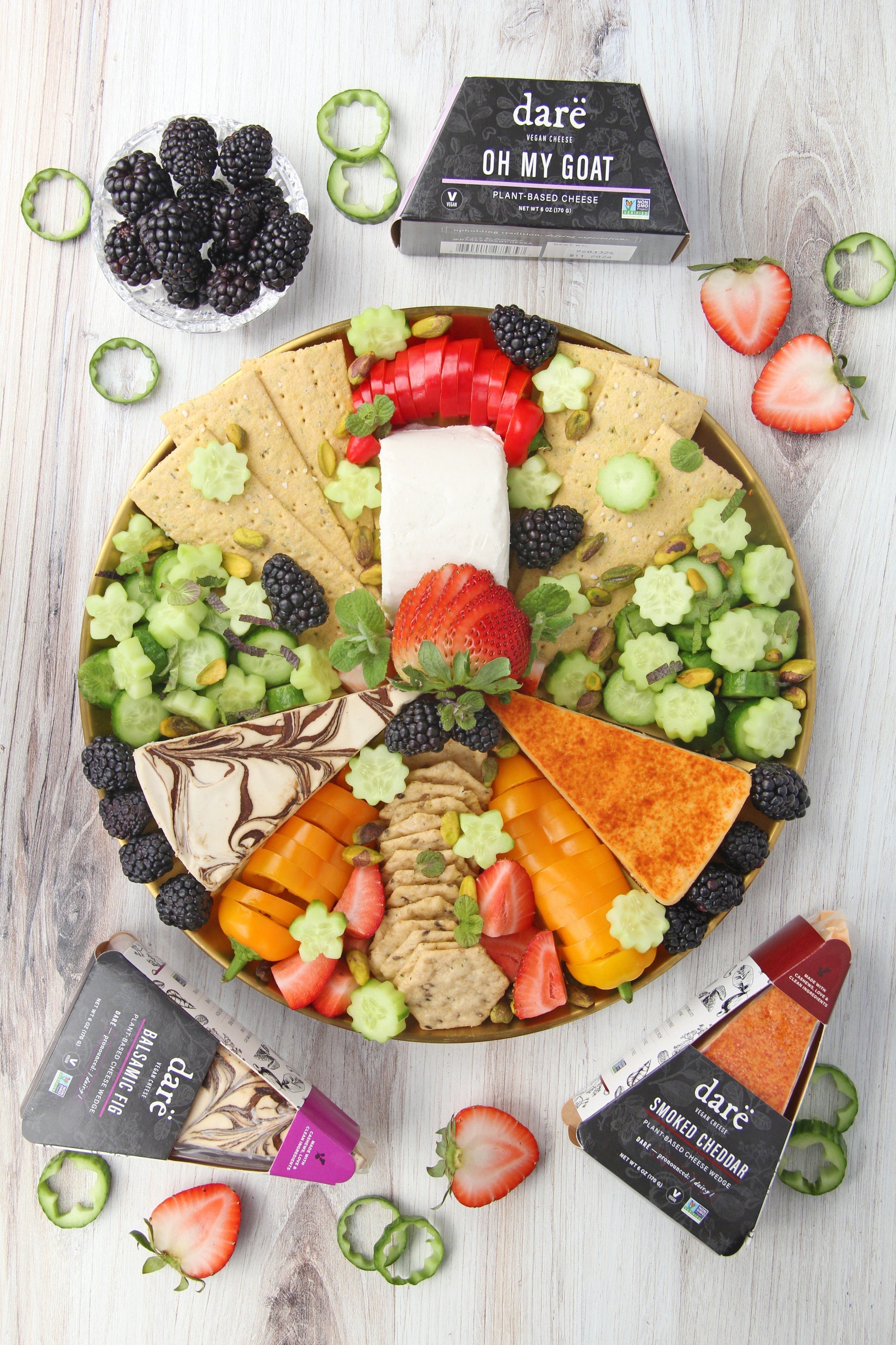 Vegan cheeseboard with fresh vegetables, fruit, and dare vegan cheeses