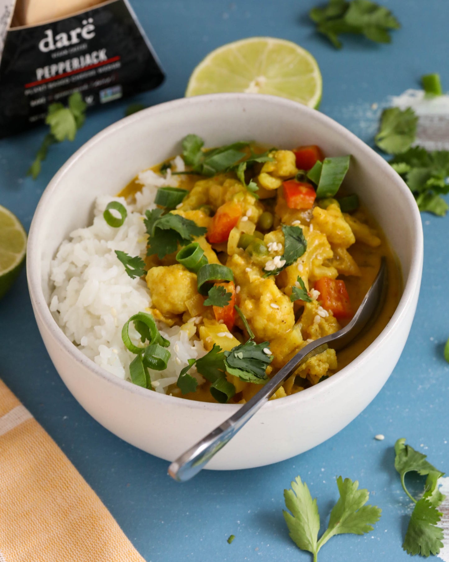 Bowl of curry with rice on a blue background, featuring 'dare' pepperjack cheese.