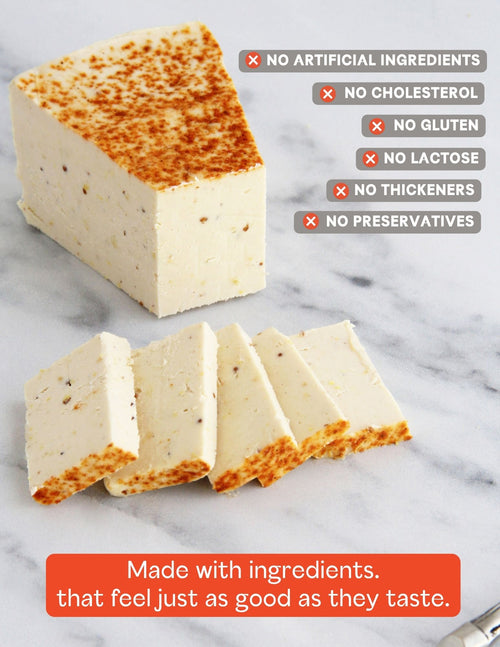 Load image 1 in gallery view. A slice of Darë Vegan Cheese Lusty Mustard plant-based cheese on a light marble surface, sliced into pieces with product attribute copy overlaid.