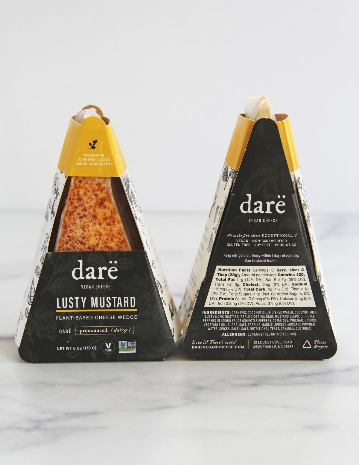 Darë Vegan Cheese Lusty Mustard plant-based cheese in its charcoal and mustard packaging, the front and back showing on a light marble surface.