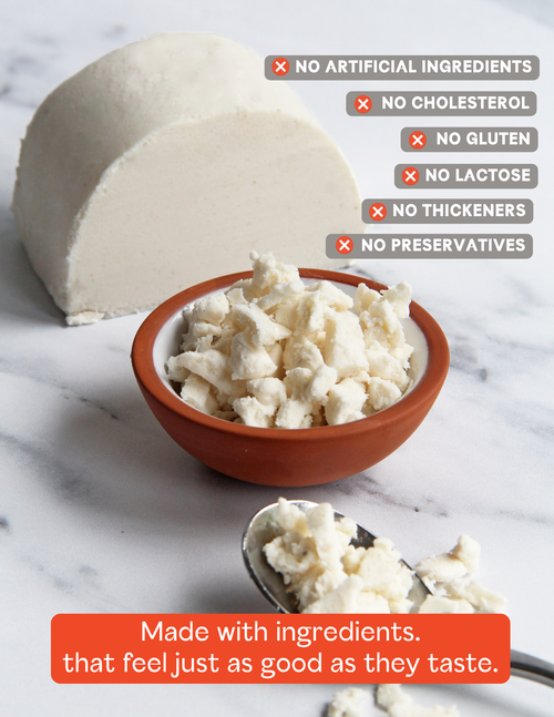 Load image 1 in gallery view. A semi-circular block of Dare Vegan Cheese goat cheese next to a small terracotta bowl filled with crumbled vegan goat cheese, on a light marble surface. Text overlays highlight product benefits such as no artificial ingredients, no cholesterol, no gluten, no lactose, no thickeners, and no preservatives.