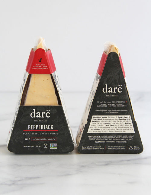Load image 1 in gallery view. Darë Vegan Cheese Pepperjack plant-based cheese in its charcoal and red packaging, the front and back showing on a light marble surface.