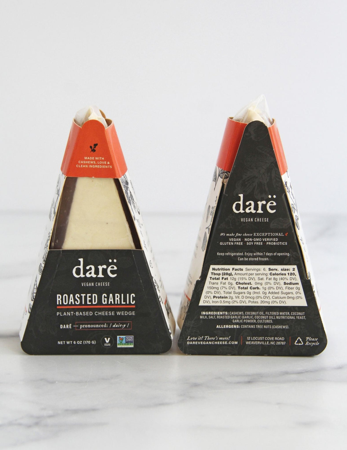 Darë vegan cheese Roasted Garlic plant-based cheese in its charcoal and orange packaging, the front and back showing on a light marble surface.
