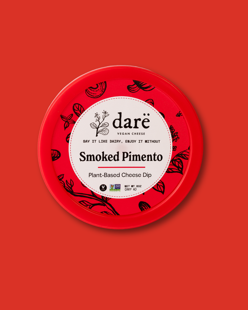 Red container of dare Smoked Pimento plant-based cheese dip on a red background