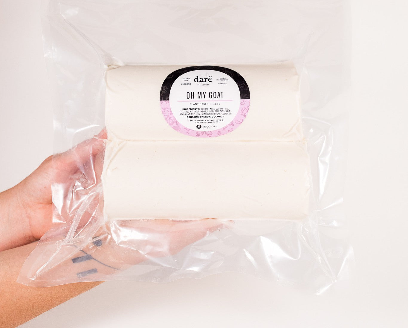 Hand holding a 3 pound wrapped product labeled 'Oh My Goat' with 'dare' branding.