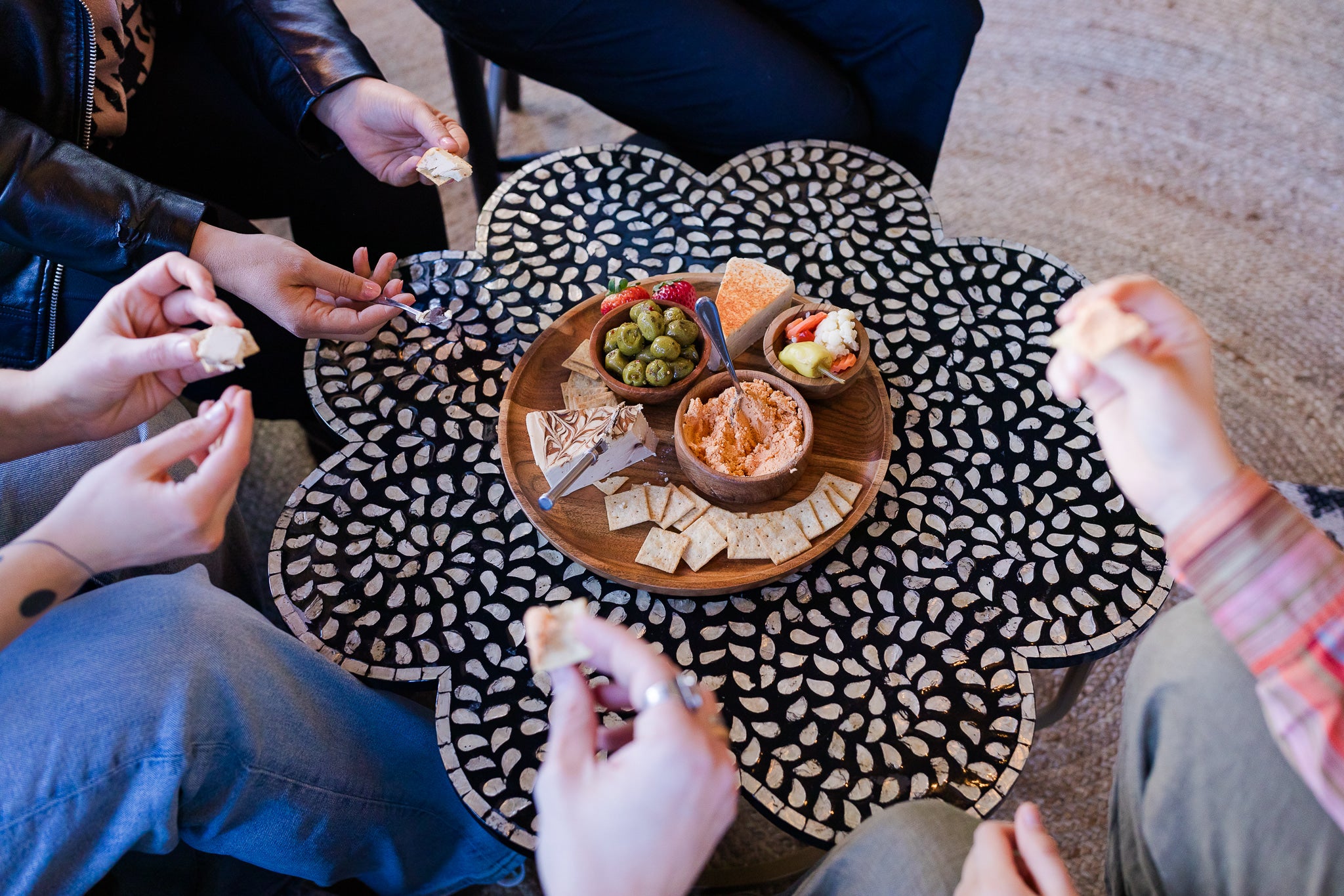 Friends gathered enjoying a Darë Vegan Cheese cheeseboard 