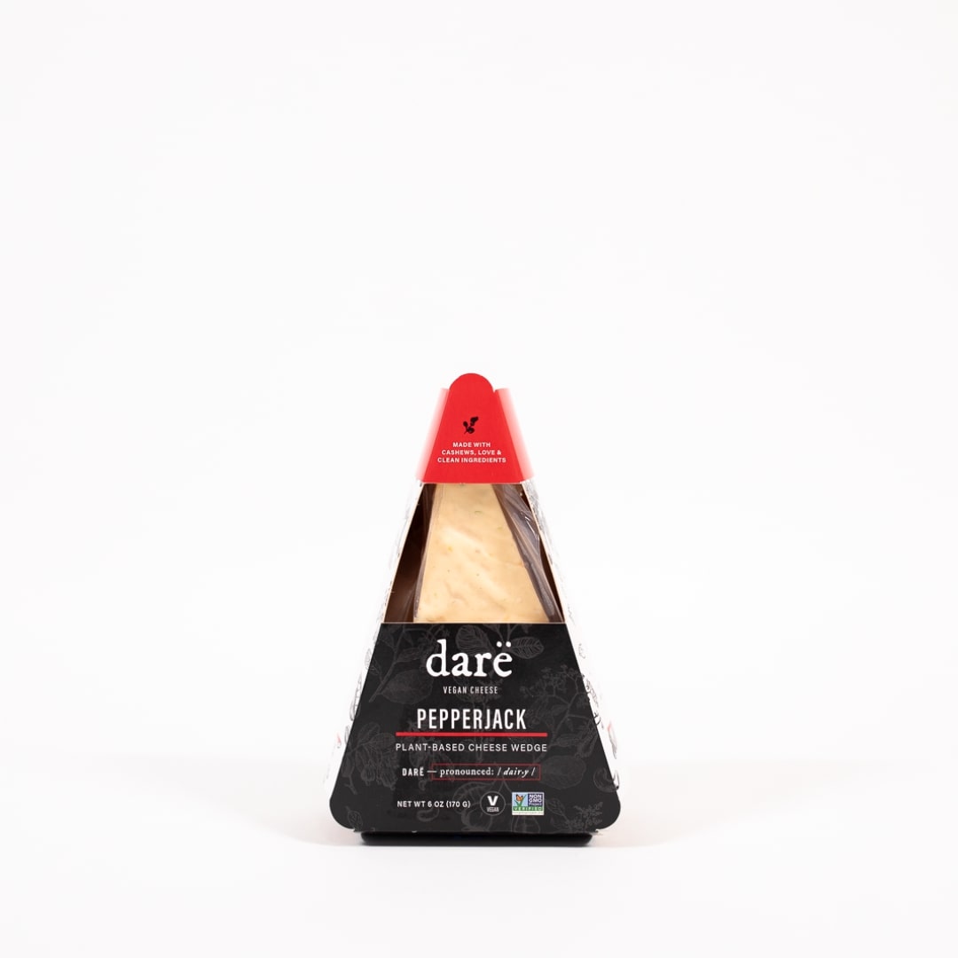 product photo of vegan cheese wedge. black and red paper container. labeled as dare vegan cheese pepperjack