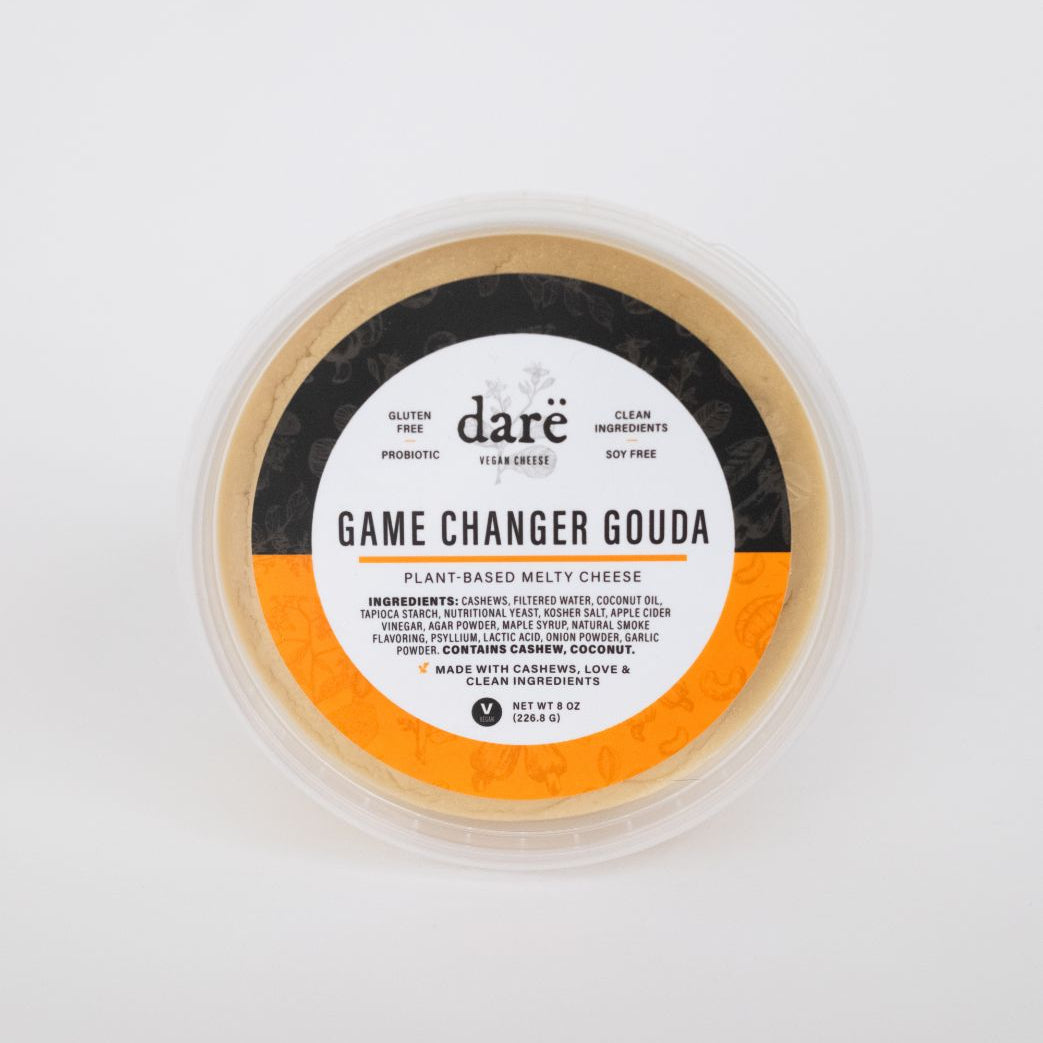 dare vegan cheese container on white background. label leads game changer gouda, orange and black container.