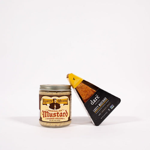 Load image 1 in gallery view. Lusty Mustard Vegan Dragon Cheese Wedge leaning on lusty monk mustard container. products set on white backdrop