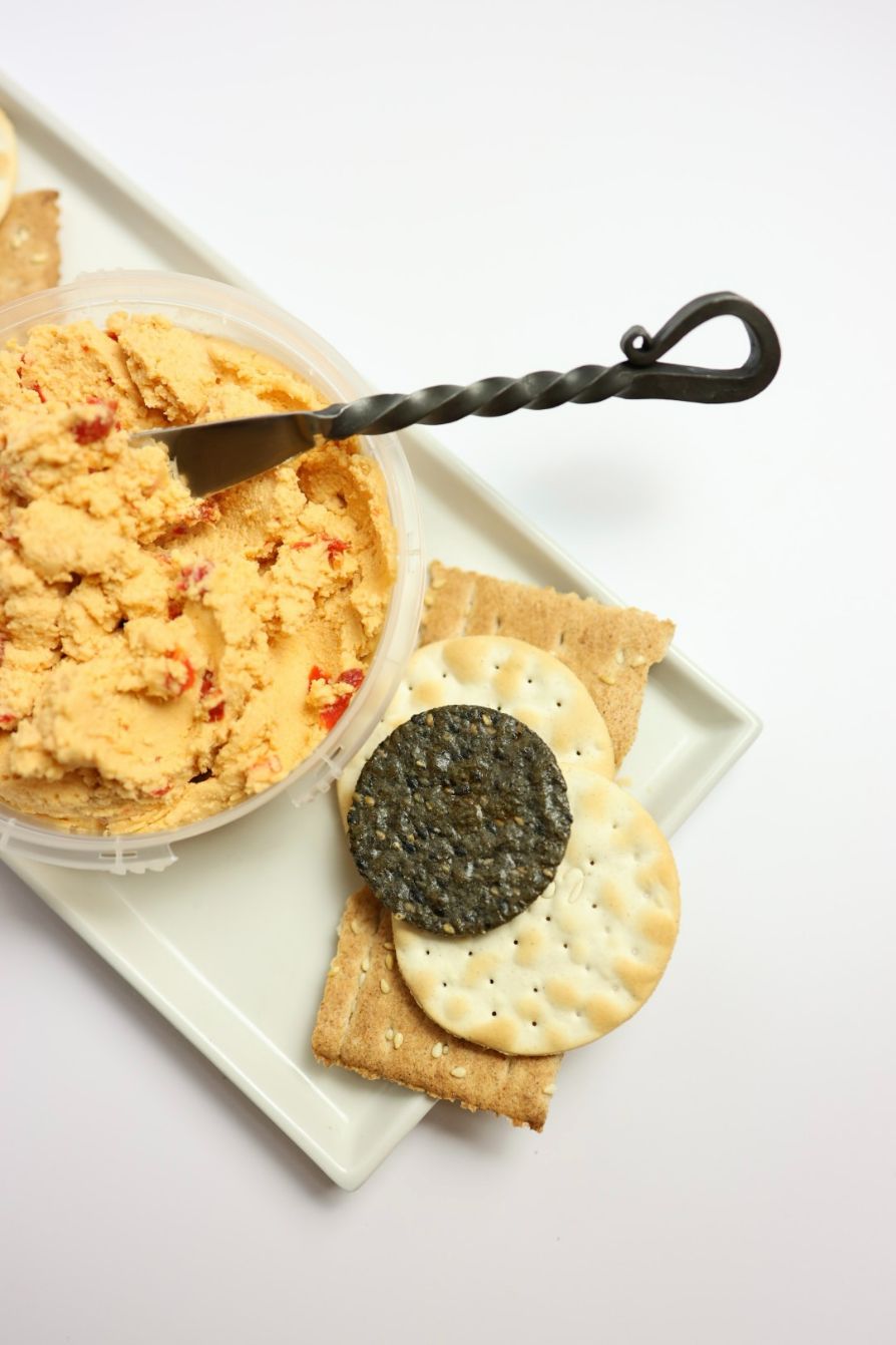 vegan pimento cheese with spreader knife and crackers on plate